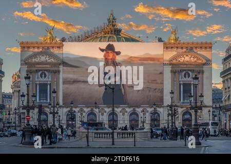 Parigi, Francia - 12 17 2023: Boulevard Haussmann. Facciata del Palazzo dell'Opera Garnier di Parigi con impalcature decorate con una cowgirl Foto Stock