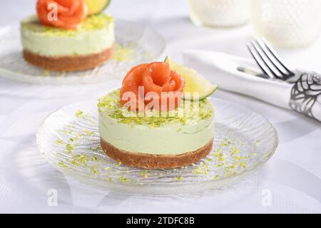 Antipasto timbale a base di avocado, montato con crema di formaggio soffice e lime su crosta corta con salmone. Un'ottima opzione per un menu delle vacanze. Foto Stock