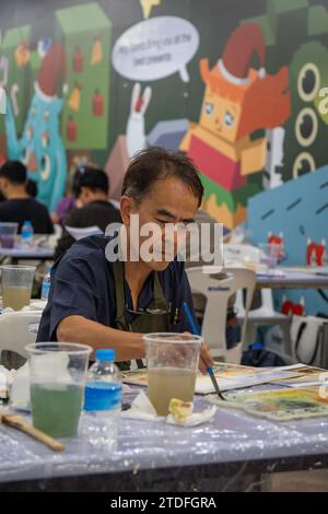Bangkok, Thailandia. 8 dicembre 2023. Un uomo tailandese è visto dipingere con acquerelli al concorso di acquerelli 'BEM Art Contest', presso la stazione MRT Phahon Yothin. La "Metro Art" presso la stazione MRT Phahon Yothin, sviluppata dalla Bangkok Expressway and Metro Public (BEM), Bangkok Metro Networks Limited (BMN), e supportato dall'Autorità del Turismo della Thailandia (TAT) è la nuova destinazione Art Space and Art nel cuore della città, poiché la stazione MRT Phahon Yothin collega tutte le aree di Bangkok, dove i visitatori possono imparare le arti in vari campi, fare shopping e vendere opere d'arte. (Immagine di credito: © Nathalie J Foto Stock