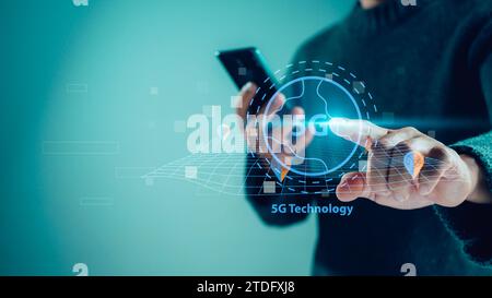Primo piano della mano umana che tiene lo smartphone e punta all'ologramma 5G, sistema di rete wireless 5G, concetto di rete 5G, Internet mobile ad alta velocità, novità Foto Stock