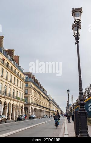 Parigi, Francia, 2023. I ciclisti si divertono nella pista ciclabile di rue de Rivoli, famosa per i suoi famosi negozi, gli eleganti caffè e gli hotel di lusso (verticale) Foto Stock