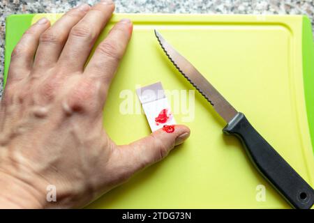 In den Finger geschnitten mit Blut zur Behandlung und Schutz mit Pflaster zu Hause Foto Stock