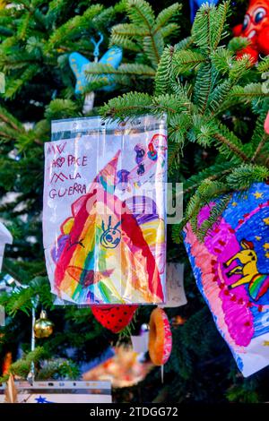 Messaggio di pace e contro la guerra disegnato da un bambino sull'albero di Natale al mercatino di Natale di Piazza Navona, Roma, Italia Foto Stock