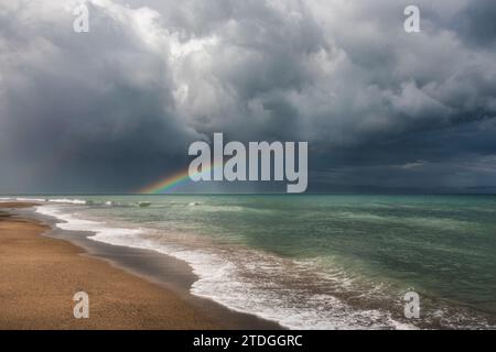 Un arcobaleno sta scomparendo in mezzo a nuvole tempestose Foto Stock