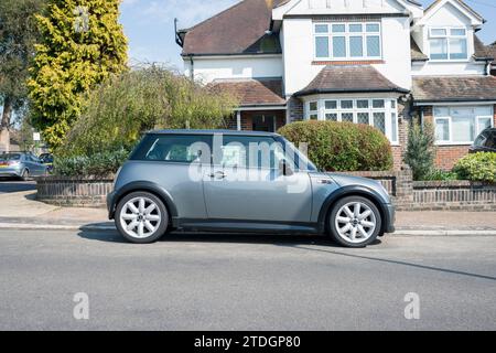 Una Mini Cooper S del 2005 è parcheggiata di fronte a una casa residenziale sulla strada. Foto Stock