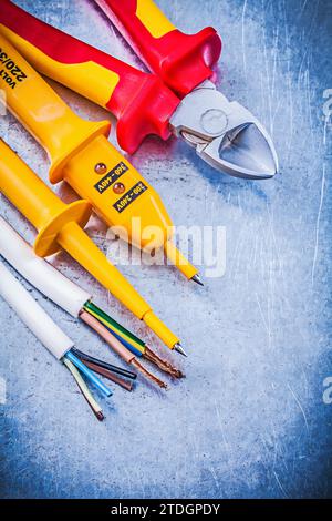 Pinze da taglio per fili per tester elettrici gialle su fondo metallico concetto di elettricità Foto Stock