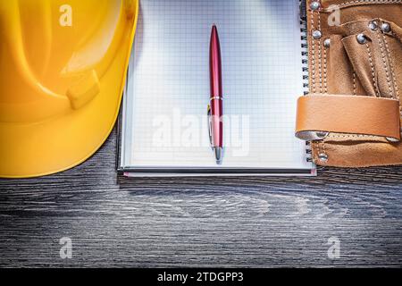 Copybook per casco da costruzione in pelle su una tavola di legno direttamente sopra Foto Stock