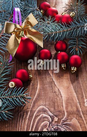 Grande composizione di giocattoli di Natale baule rosse arco color oro e rami di abete su un vecchio pannello di legno con piccolo spazio copiato Foto Stock