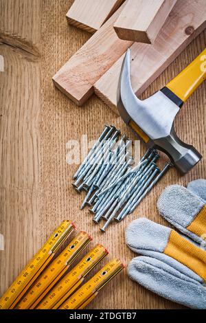 Composizione di chiodi per utensili di carpenteria guanto di protezione in legno griffe martellate su tavola di legno Foto Stock