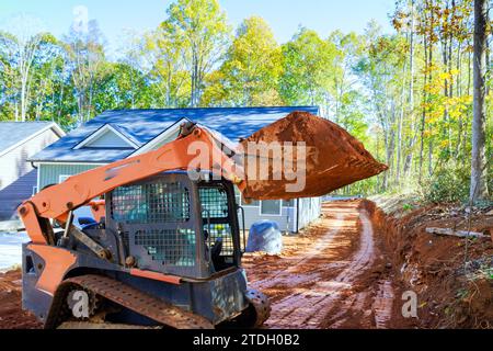 Un mini bulldozer per movimento terra viene utilizzato per attività di architettura paesaggistica che migliorano il territorio Foto Stock