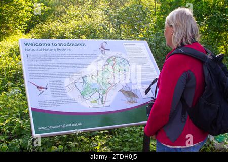 Birdwatcher che legge la Reserve Information Board Foto Stock