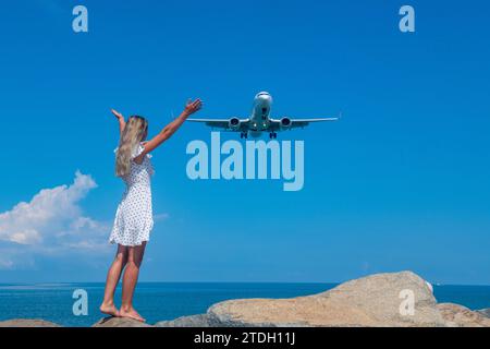 Merging Horizons: Girl in White Dress on Stones, Meeting of Sea and Sky Foto Stock