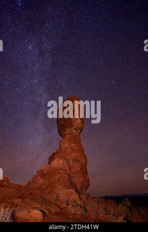 Estremità settentrionale della via Lattea sopra Balanced Rock all'Arches National Park in inverno nello Utah. Foto Stock