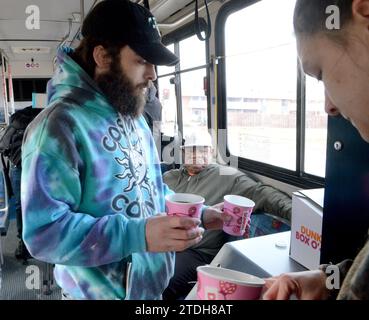 Racine, Wisconsin, USA. 18 dicembre 2023. TYLER TOWNSEND e la sua fidanzata RHONDA RANGEL stavano tornando a casa da una vacanza quando sono passati davanti all'edificio in fiamme di Parkview Manor a Racine. Wisconsin. Sono andati a prendere un caffè per i residenti che stavano prendendo riparo dal freddo su un autobus cittadino dopo l'incendio lunedì mattina 18 dicembre 2023. (Immagine di credito: © Mark Hertzberg/ZUMA Press Wire) SOLO USO EDITORIALE! Non per USO commerciale! Foto Stock