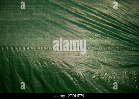 Tessuto verde in tessuto di plastica. Tenda verde. Superficie irregolare. Teustura della tenda. Foto Stock