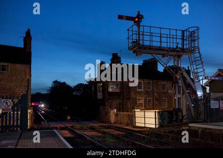 Treno Northern Rail classe 170 TurboStar che arriva alla stazione ferroviaria di Knaresborough al crepuscolo, con segnale a forcella e semaforo Foto Stock