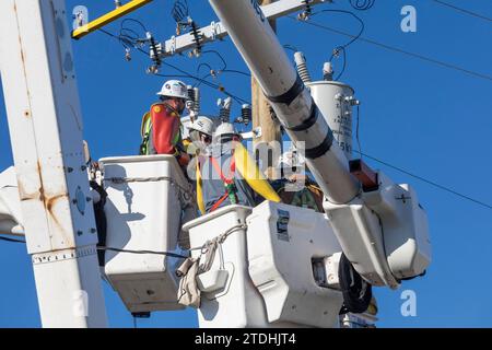 Detroit, Michigan - gli addetti alla linea elettrica, che lavorano per DTE Energy, sostituiscono le apparecchiature di trasmissione su un palo elettrico. Foto Stock