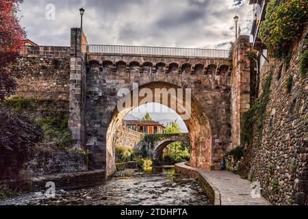 Città medievale di Potes con ponte e fiume Deva lungo il suo percorso. Nella regione di Liebana, Cantabria, Spagna. Foto Stock