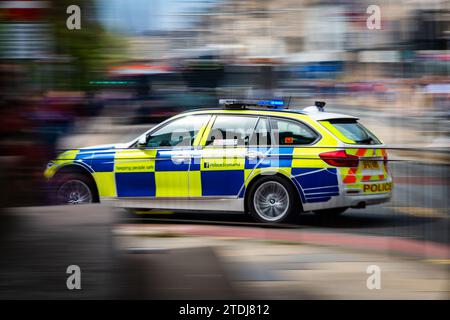 Motion Photo - Una Blue Light Police Scotland BMW 330D Police Car attraversa Princes Street, Edimburgo, Scozia, Regno Unito. Risposta di emergenza Foto Stock