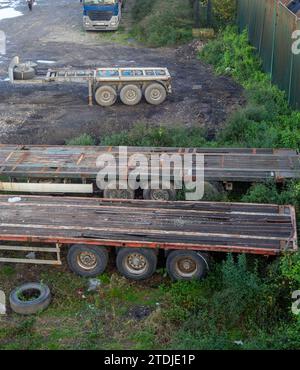 Vecchi vagoni per camion. Trasporto abbandonato. Vecchi rimorchi senza capote Foto Stock