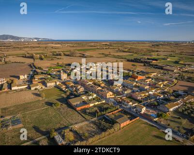 Vista aerea del villaggio di Riumors, dei campi e dei dintorni rurali in un pomeriggio autunnale (Alt Empordà, Girona, Catalogna, Spagna) Foto Stock