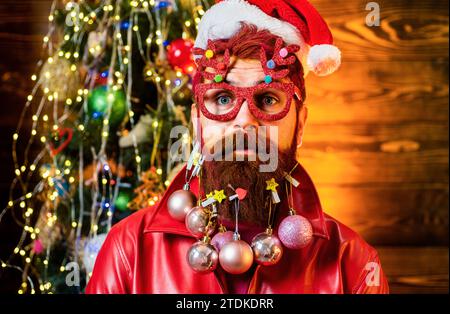 Santa felice vestita in abiti invernali pensa a Natale vicino albero di Natale. Ritratto di Babbo Natale. Concetto di anno nuovo. Natale a casa Foto Stock