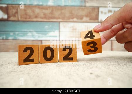 Capovolgimento da 2023 a 2024 su blocchi cubici di legno. A partire dal nuovo anno 2024. Inizio del 2024. Pianificazione del nuovo anno, risultati, obiettivi, business, pla Foto Stock