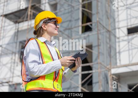 Donne lavoratrici ingegnere edile intelligente architetto caucasico donna che guarda sotto progetto di costruzione edile. Foto Stock