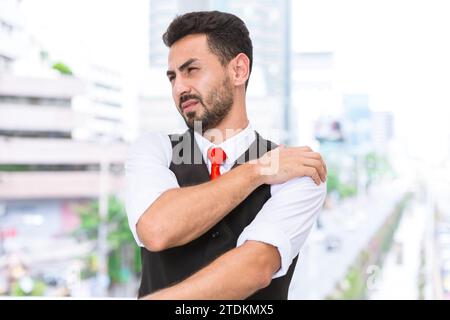 Ispanico indiano uomo d'affari dolore alla spalla muscolo del braccio si uniscono crampi dalla sindrome dell'ufficio dopo una dura giornata di lavoro. Foto Stock
