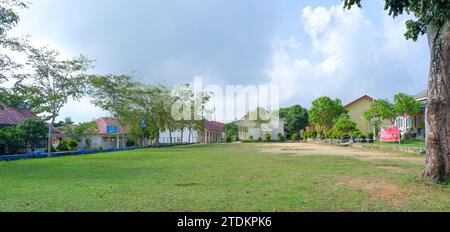 Vista naturale del cortile scolastico con erba Verde e diversi edifici durante il giorno Foto Stock