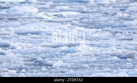 Frammenti di ghiaccio che si scioglie ricoperti di neve bagnata galleggiano sulle acque del Mar Baltico, foto di sfondo naturale invernale con messa a fuoco morbida selettiva Foto Stock