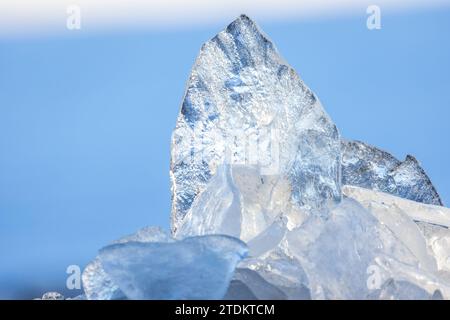 Frammenti di ghiaccio trasparenti in una soleggiata giornata invernale, foto ravvicinate con messa a fuoco morbida selettiva Foto Stock