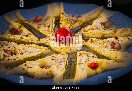 Ciotola di hummus. Hummus classico con prezzemolo su un piatto. Insalata tradizionale di hummus. Cucina mediorientale o araba. Piatti di ceci, una vegetaria Foto Stock