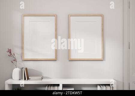 Due cornici per immagini mockup su una parete bianca e una libreria bianca in una stanza minimalista bianca. immagine vista frontale. rendering 3d, illustrazione 3d. Foto Stock