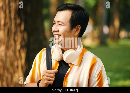 Ritratto di uno studente universitario vietnamita sorridente con zaino che cammina nel campus universitario Foto Stock