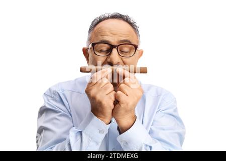 Uomo maturo che si gode e annusa un sigaro isolato su sfondo bianco Foto Stock