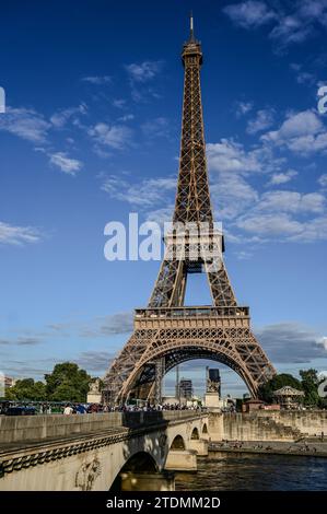 Parigi, Francia, 1 luglio 2022. La Torre Eiffel vista dalla riva opposta della Senna. La calda luce del tardo pomeriggio lo illumina completamente. Blu sk Foto Stock