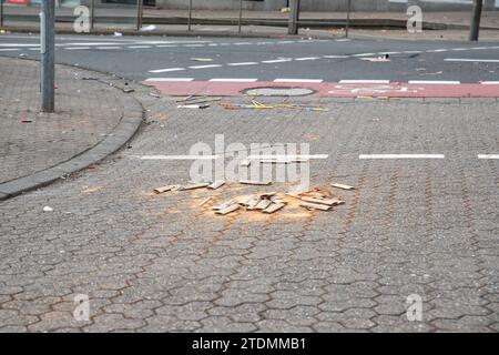 La spazzatura del lanciarazzi fuochi d'artificio rimane sulla strada tedesca della città dopo la festa di Silvester tradizionale. Spazzatura di rifiuti rovinati dai falciatori Foto Stock