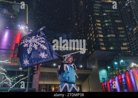 Un performer onda agli spettatori della parata a Bellevue. Quasi un migliaio di persone hanno festeggiato il Natale insieme a Bellevue. C'è stato un evento chiamato "Snowflake Parade", la più importante festa di Natale all'aperto a Seattle. Snowflake Lane ha appena iniziato il suo 22° anno presso la Bellevue Collection, offrendo un'esperienza unica per la gente del posto di tutte le età fino a Natale. Partecipa a una parata di 30 minuti lungo Bellevue Way tra Bellevue e Lincoln Square e potrai goderti la neve che cade, la musica natalizia, i batteristi giocattolo, i ballerini e diversi personaggi a tema natalizio. Bellevue Way Northeast e. Foto Stock