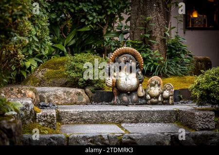 Statua tradizionale di procione giapponese in un giardino di Kyoto Foto Stock