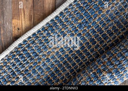 Tappeto in denim geometrico intrecciato a mano su pavimento in legno. Foto Stock