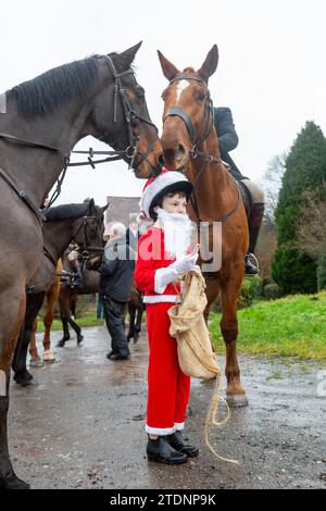 Upper Arley, Kidderminster, Worcestershire, Regno Unito. 19 dicembre 2023. Henley Mills, un bambino di 10 anni vestito da Babbo Natale, distribuisce barrette di cioccolato ai membri della caccia ad Albrighton e Woodland mentre fanno un giro sul prato da una fattoria nell'Upper Arley, vicino a Kidderminster nel Worcestershire. Crediti: Peter Lopeman/Alamy Live News Foto Stock