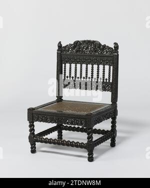 Sedia con uccelli simili a pappagallo, anonimo, c. 1650 - c. 1700 sedia in ebano basso con seduta libera, rivestita con treccia di rattan, gambe a alette con case e regole a sbalzo. Le case, le regole di informazione e gli stili retrostanti mostrano rosette e offerte. Secondo le regole dei posti a sedere, scultura aperta con due campioni alati e tendine. Uccelli simili a pappagalli sullo sfondo. Tra i batticalcagno vi sono nove colonne con lettere maiuscole, tra cui otto gemme. La sedia mostra sculture con, tra le altre cose, teste alate, figure femminili e campioni. Legno dello Sri Lanka (materiale vegetale). ebano (legno). ra Foto Stock