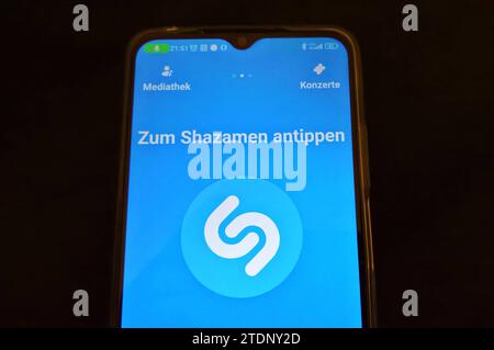 Shazam ist eine App für mobile Geräte und Personal computer, die durch die Möglichkeit, laufende Musik zu erkennen, bekannt wurde. Shazam kann aufgenommene Audiosequenzen analysieren und dazu, basierend auf einem akustischen Fingerabdruck, den Titel und weitere passende Informationen aus Shazams Datenbank anzeigen. Foto: Smartphone Shazamen auf einem *** Shazam è un'app per dispositivi mobili e personal computer che è diventata nota per la sua capacità di riconoscere la musica in corso Shazam può analizzare sequenze audio registrate e, sulla base di un'impronta digitale acustica, visualizzare il titolo e altre corrispondenze Foto Stock