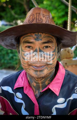 Lampang, Thailandia - 2 dicembre 2023: Ritratto di un uomo tailandese con un tatuaggio sul viso, un tatuatore di carrozze trainate da cavalli a Lampang, Thailandia. Foto Stock