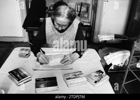 Ritratto di una donna più anziana, signora Davidson, che scrive su una grande pila di biglietti di Natale, Haarlem, Gaelstraat, Paesi Bassi, 20-12-1979, Whizgle News dal passato, su misura per il futuro. Esplora le narrazioni storiche, l'immagine dell'agenzia olandese olandese con una prospettiva moderna, colmando il divario tra gli eventi di ieri e quelli di domani. Un viaggio senza tempo che delinea le storie che plasmano il nostro futuro Foto Stock