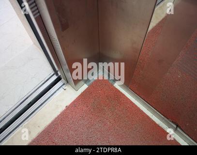 Un angolo metallico di un ascensore con porta aperta. Foto Stock