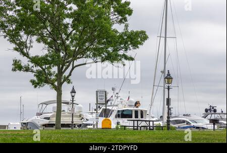 una donna che pulisce uno yacht al parco marino Foto Stock