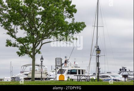 una donna che pulisce uno yacht al parco marino Foto Stock