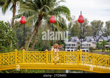 Donna che gode di momenti sereni su un ponte giallo vibrante in un ambiente tropicale. Viaggi e tempo libero. Foto Stock